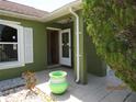 A nice green potted plant sits on the tiled front porch near the open front door at 1155 Roan Ct, Kissimmee, FL 34759