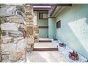 Inviting front entrance with stone accents, a walkway, and landscaping, creating a welcoming ambiance at 12 Robyn Ln, Haines City, FL 33844