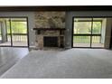 Cozy living room featuring a stone fireplace and sliding doors to a covered patio at 12 Robyn Ln, Haines City, FL 33844