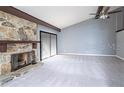 Spacious living room with a stone fireplace, vaulted ceilings, and ample natural light at 12 Robyn Ln, Haines City, FL 33844