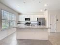 Bright kitchen features a large island, white cabinets, and stainless steel appliances at 12035 Holystone St, Winter Garden, FL 34787