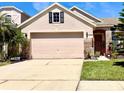 Charming single-Gathering home featuring a large two-car garage, brick accents, and well-manicured lawn at 14945 Huntcliff Park Way, Orlando, FL 32824