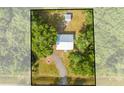 Aerial view of the home and large lot with tree coverage and a detached structure at 150 N Post Office Rd, Kenansville, FL 34739