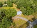 Aerial view of home on a large lot with tree coverage and a long driveway at 150 N Post Office Rd, Kenansville, FL 34739