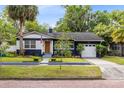 Inviting blue home boasts a well-kept lawn, shade trees, and a brick-paved street at 1510 E Ridgewood St, Orlando, FL 32803