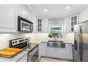 Stylish white kitchen featuring modern appliances, a stainless steel sink, and subway tile backsplash at 1510 E Ridgewood St, Orlando, FL 32803