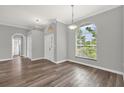 Bright living room with wood floors, modern paint, arched windows, and views of the outdoors at 1532 Reade Cir, St Cloud, FL 34772
