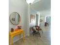 Hallway with tile floors and a stylish yellow table with decor at 1599 Thetford Cir, Orlando, FL 32824