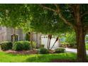 Lovely home exterior featuring mature trees, lush landscaping, stone accents, and a two-car garage at 1607 Tail Feather Dr, Kissimmee, FL 34746