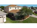 A view of a well-manicured backyard and landscaped side yard. The house is two stories with a brown roof at 1915 Acacia Dr, Kissimmee, FL 34758