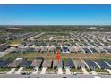 Wide aerial view showing the neighborhood's layout and proximity to green spaces and amenities at 219 Summerlin Loop, Haines City, FL 33844