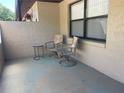 Cozy condo patio with two chairs, a small table, and a window at 2246 Firestone Pl, Winter Haven, FL 33884