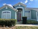 Inviting front entrance with a red door, white trim, and well-maintained landscaping at 2714 University Acres Dr, Orlando, FL 32817