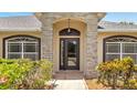 Inviting front entrance with stone pillars, arched entryway, and well-manicured landscaping at 2801 Palmyra Ct, St Cloud, FL 34772