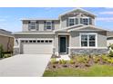 Charming two-story home featuring gray siding, stone accents, and a well-manicured front yard at 2943 Gavin Sky Dr, Kissimmee, FL 34744