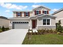 Inviting two-story home with a two-car garage, stone accents, and red shutters at 2961 Gavin Sky Dr, Kissimmee, FL 34744
