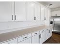 Stylish kitchen featuring white cabinets, quartz countertops, and stainless steel refrigerator at 2961 Gavin Sky Dr, Kissimmee, FL 34744