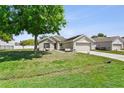Charming single-story home with a well-manicured lawn and a two-car garage during daylight at 323 Azincourt Ln, Kissimmee, FL 34759