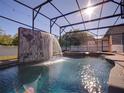Sparkling in-ground pool with a custom waterfall feature, spa, and a screened-in enclosure at 3245 Heirloom Rose Pl, Oviedo, FL 32766