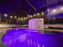 Inviting in-ground screened-in pool with a custom waterfall feature and in-pool lighting at 3245 Heirloom Rose Pl, Oviedo, FL 32766