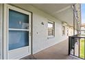 Apartment entrance featuring a screen door, small window, and a concrete walkway at 333 Lake Howard Dr Nw # 204D, Winter Haven, FL 33880