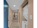 Hallway with a stackable washer and dryer leading to the living room at 333 Lake Howard Dr Nw # 204D, Winter Haven, FL 33880