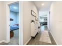 Inviting hallway with wood floors, stylish decor, and doorway view to bedroom with blue bedding at 372 Meadow Pointe Dr, Haines City, FL 33844