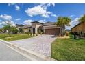Inviting home with a well-maintained lawn and a brick-paved driveway leading to a two-car garage at 3775 Via Mazzini Ct, Kissimmee, FL 34759