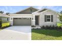 Beautiful home featuring stone accents, a gray garage door, and a well-manicured lawn at 4075 Bannock Ave, Tavares, FL 32778