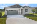Beautiful home featuring stone accents, a gray garage door, and a well-manicured lawn at 4075 Bannock Ave, Tavares, FL 32778