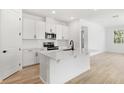 Modern kitchen featuring white cabinets, an island, and stainless steel appliances at 4076 Bannock Ave, Tavares, FL 32778