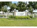 Community sign for Lakeside Forest with a landscaped bed, white fence and mature trees at 4083 Bannock Ave, Tavares, FL 32778