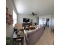 Comfortable living room with neutral colors, tile flooring, fan, and plenty of natural light at 426 Citrus Isle Loop, Davenport, FL 33837