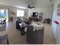 Open concept living room with tile floors, ceiling fan, ample windows, and comfortable furniture at 426 Citrus Isle Loop, Davenport, FL 33837