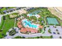 Aerial view showcasing community amenities with large pools, tennis courts, and lush landscaping in a neighborhood at 4751 Terrasonesta Dr, Davenport, FL 33837