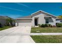 A well-maintained single-story home with a two-car garage, complemented by a green lawn and landscaping at 5140 Four Strand Ct, St Cloud, FL 34772