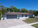Charming one-story home featuring a blue exterior, paver driveway, and manicured lawn at 600 Swallow Dr, Casselberry, FL 32707