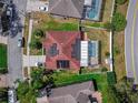 Birds eye view of single-story home with a covered pool, solar panels, and well-maintained landscaping at 6017 Hickory Grove Ln, Port Orange, FL 32128