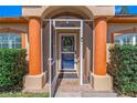 Inviting front door with decorative pillars, a tiled entryway, and lush green shrubbery on a sunny day at 6017 Hickory Grove Ln, Port Orange, FL 32128