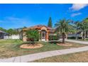 Charming home featuring landscaped front yard with mature palm trees and a welcoming entrance at 6017 Hickory Grove Ln, Port Orange, FL 32128