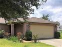 The exterior of the home showcases its two-car garage, tidy landscaping, and appealing color scheme at 610 Yak Ct, Kissimmee, FL 34759