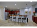Kitchen features a breakfast bar with seating, stainless steel appliances and dark wood cabinets at 7664 Wilmington Loop, Kissimmee, FL 34747