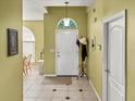 Inviting entryway with tile flooring, coat rack, and view into the dining area at 7733 Beridale Ct, Orlando, FL 32818