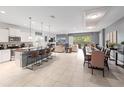 Spacious living space featuring modern kitchen, seating at bar, and adjoined living and dining areas at 8879 Qin Loop, Kissimmee, FL 34747