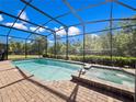 Relaxing screened-in pool area with a spa and brick patio, perfect for outdoor enjoyment at 8879 Qin Loop, Kissimmee, FL 34747