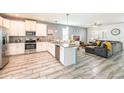Open-concept kitchen with stainless steel appliances, granite countertops, and an island at 9036 Stinger E Dr, Davenport, FL 33896