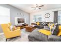 Cozy living room with a comfortable sectional sofa, a wooden coffee table, and a ceiling fan at 9036 Stinger E Dr, Davenport, FL 33896