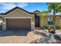 Inviting home showcasing a well-manicured lawn, stone accents, and a brown garage door at 164 Montoro Ln, Davenport, FL 33837