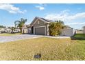 Lovely single-story home featuring a paver driveway, a well manicured lawn, and a two-car garage at 1654 Chatsworth Cir, St Cloud, FL 34771