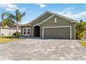 Beautiful one-story home boasting a paver driveway, attached garage and manicured lawn at 1654 Chatsworth Cir, St Cloud, FL 34771